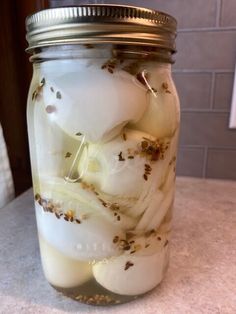 a mason jar filled with pickled onions and garlic