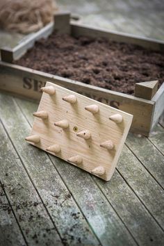 two wooden boxes filled with dirt and rocks sitting on top of a wooden floor next to each other