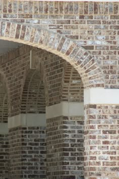 an arch in a brick building with a clock on it