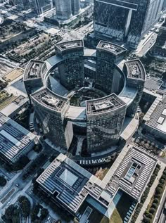 an aerial view of a circular building in the middle of a city with lots of tall buildings