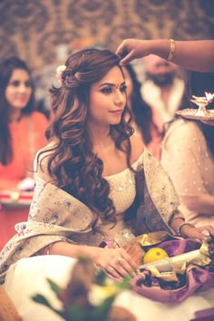 a woman is getting her hair done at a wedding