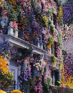 a building covered in lots of colorful flowers