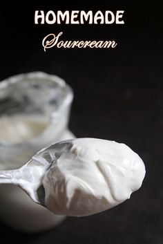 a spoon full of sour cream sitting on top of a black surface with the text homemade sour cream