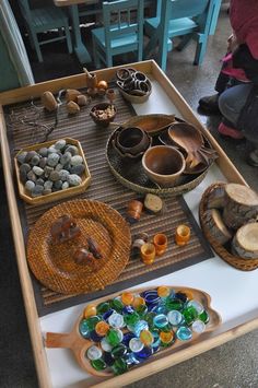 a table topped with lots of different types of bowls and trays filled with rocks