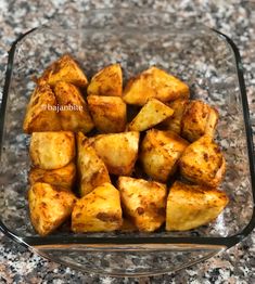 cooked potatoes in a glass dish on a granite counter top, ready to be eaten