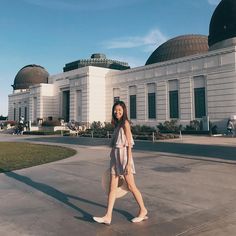 a woman walking in front of a building with domes on the top and bottom of it