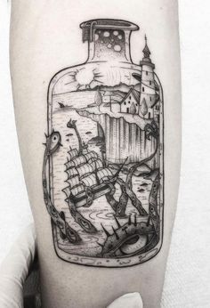 a man's leg with a bottle tattoo on it that has an image of people inside