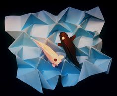 an origami fish and another animal are in the middle of a paper sculpture