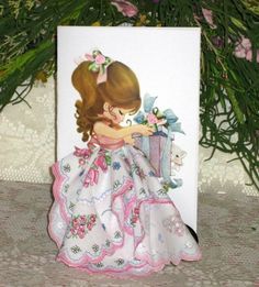 a greeting card with a girl holding a present