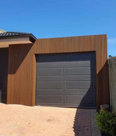 two garages are shown in front of a brick driveway and fenced in area