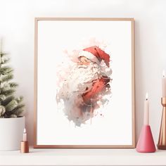 a framed photograph of santa claus on a shelf next to candles and a potted christmas tree