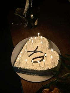 a birthday cake with candles in the shape of an x on it, sitting on a table