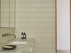 a bathroom with a sink, mirror and soap dispenser on the counter