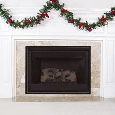 a fireplace decorated for christmas with garland and poinsettis