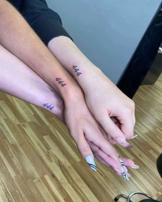 two people holding each other's hands with tattoos on their arms and the words i am