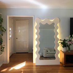 a living room filled with furniture and a large mirror on the wall next to a door