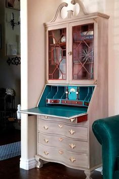 a desk with a green chair in front of it and a china cabinet behind it