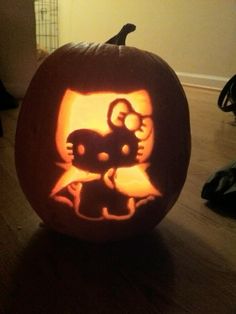 a carved pumpkin with an image of a cat and mouse on it's face