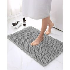 a person standing on top of a bathroom rug