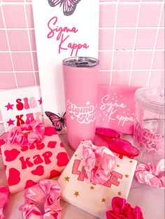 pink items are laying on the table in front of a sign and wallpapers