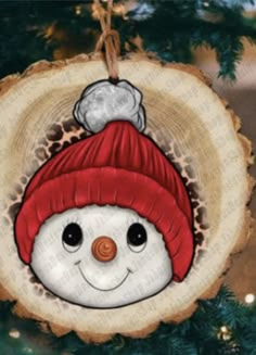 a snowman ornament hanging on a christmas tree slice with lights in the background