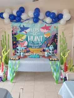 an under the sea themed birthday party with balloons and desserts on tables in front of a backdrop