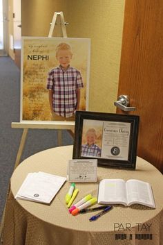 an open book sitting on top of a table next to some pens and pencils