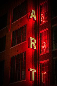 an illuminated sign on the side of a building that says arr it in neon letters