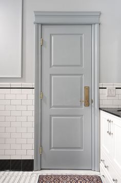 a white door in a kitchen next to a sink and counter top with a rug on the floor