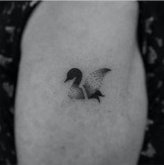 a black and white photo of a duck tattoo on the right side of the stomach