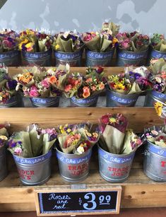 many flowers are in buckets on display for sale