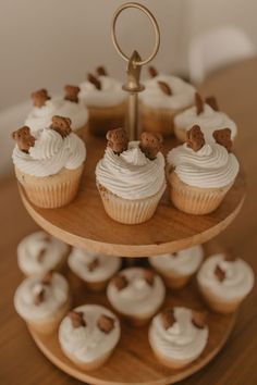 cupcakes are arranged on a three tiered tray