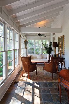 a living room filled with furniture and lots of windows