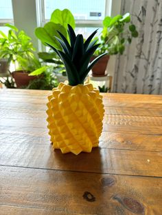 a pineapple shaped vase sitting on top of a wooden table