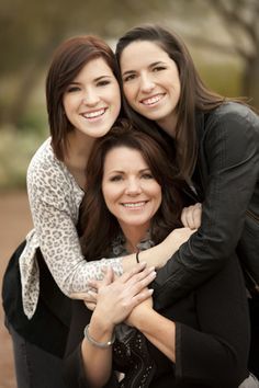 three women hugging each other and smiling for the camera