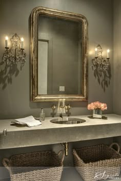 a bathroom vanity with two sinks under a large mirror and some baskets underneath the sink