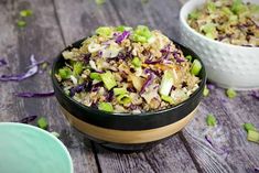 two bowls filled with food sitting on top of a wooden table next to each other