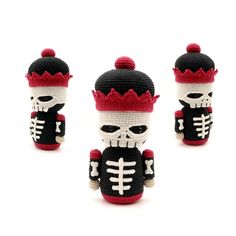 three crocheted toy figurines in different colors and sizes, one with a skull on it's head