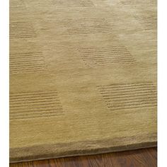 a beige rug with squares and lines on the floor in front of a wooden floor