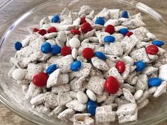 a glass bowl filled with red, white and blue puppy chow treats on top of a table