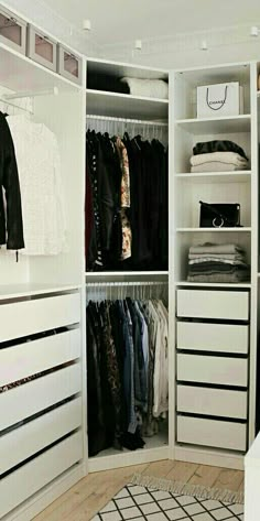 a white closet filled with lots of clothes and drawers next to a plant on top of a rug