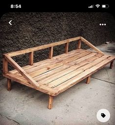 a wooden couch sitting on top of a cement floor next to a wall with an instagram button