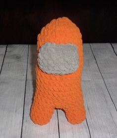 an orange stuffed animal with a gray patch on it's chest sitting on a white wood floor