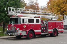 a fire truck is parked on the side of the road in front of some houses