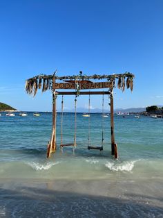 a wooden structure sitting on top of a beach next to the ocean