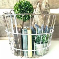 a wire basket filled with books and plants