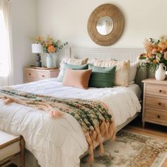 a bedroom with a bed, dressers and flowers in vases on the wall