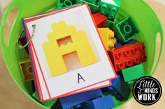 a green bucket filled with legos and building blocks