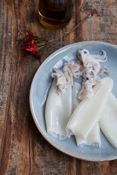 two pieces of dumplings on a plate with flowers next to it and a jar of honey in the background