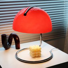 a red lamp sitting on top of a white table